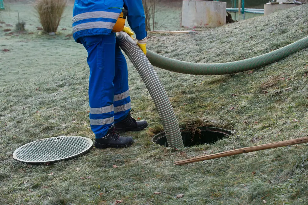 Tech pumping out a tank with a vacuum hose