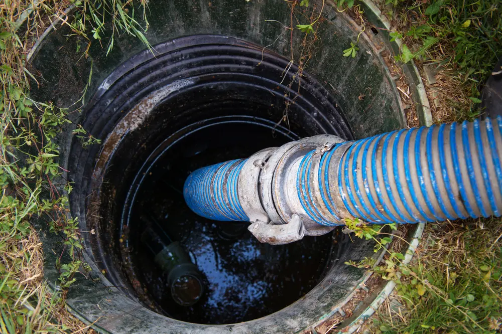 Vacuum hose inside an open septic tank
