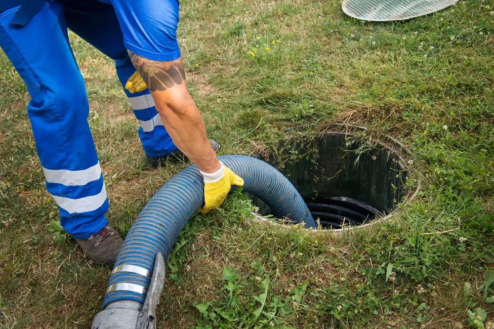 Vacuum hose connected to an open septic riser